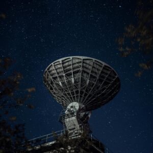 A large radio telescope beneath a starry night sky capturing celestial signals.